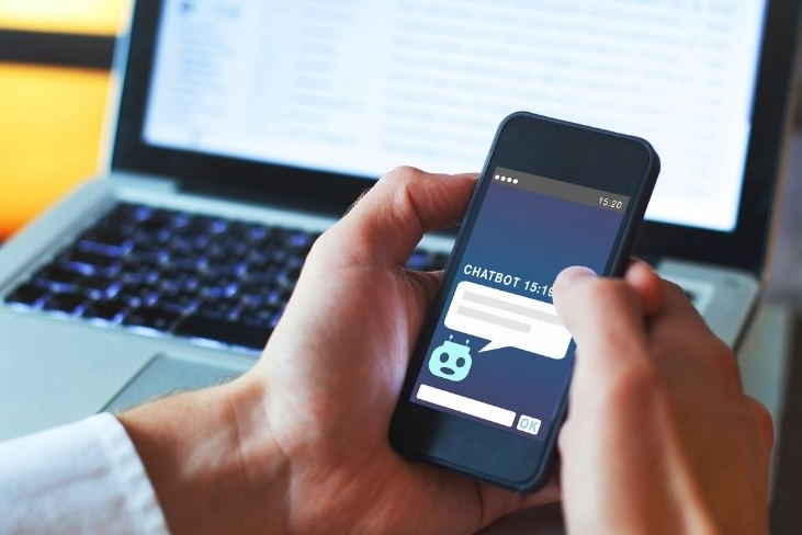 Blog schreiben mit KI: Männerhände Handy Begleitbild zu Thomas beginnt mit der Recherche: Männerhände mit Handy, dahinter ein aufgeklappter Laptop