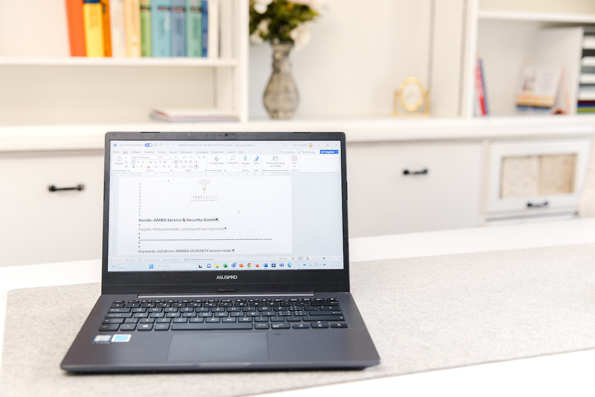 Website-Texte schreiben: aufgeklappter Laptop Begleitbild zu Website-Form: aufgeklappter Laptop auf weissem Tisch mit Bürohintergrund